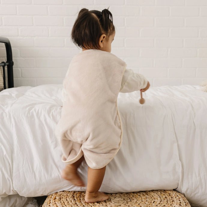 Toddler playing with her toys facing the bed